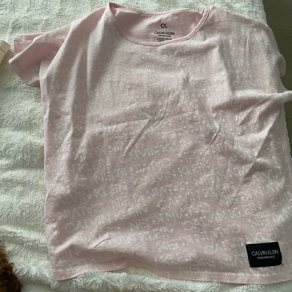 A pastel pink shirt. Size kids L/G/G (12/14). Brand Calvin Klein.